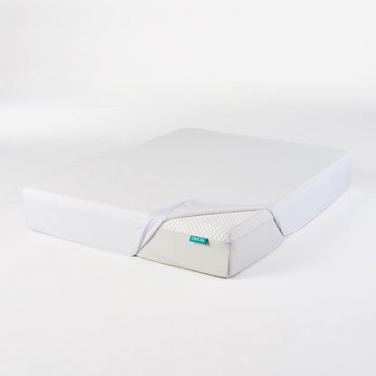 OkiOki mattress protector queen by HouseOfZazla in light gray with teal brand tag on white bed on Tampa Home & Garden Store