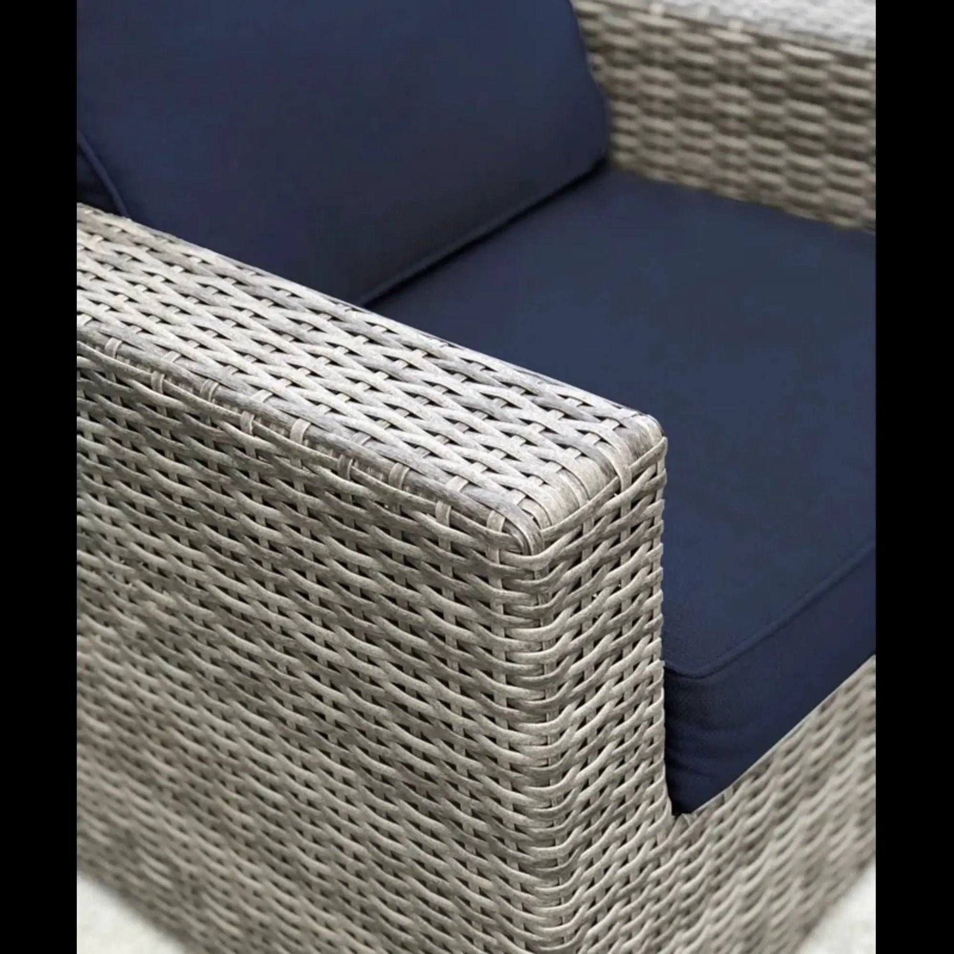 Patio arm chair with navy cushions in a woven wicker frame on Tampa Home & Garden Store