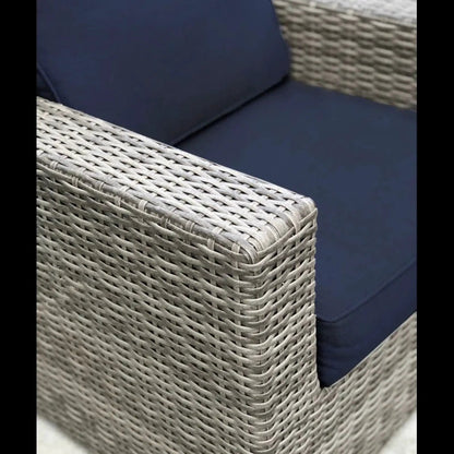 Patio arm chair with navy cushions in a woven wicker frame on Tampa Home & Garden Store