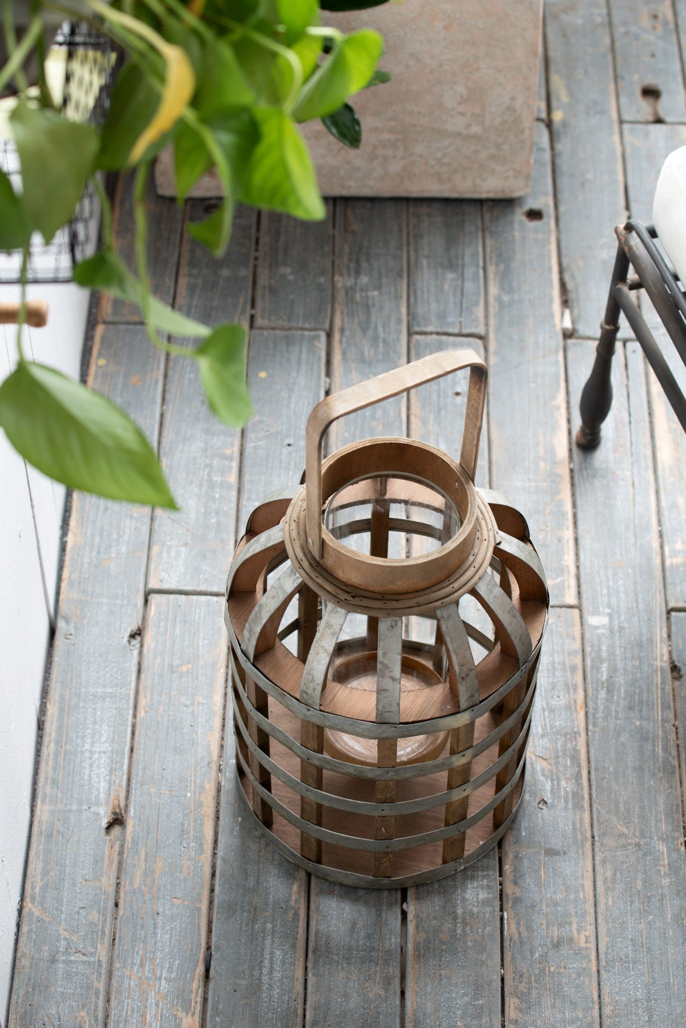 Decorative wooden lantern with handle, brown finish and metal bands on weathered deck on Tampa Home & Garden Store