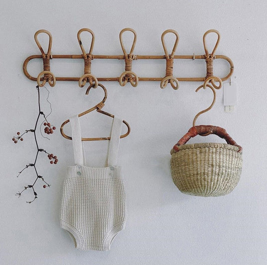 Six-hook natural rattan coat rack wall hanging with woven design; baby romper and wicker basket on Tampa Home & Garden Store