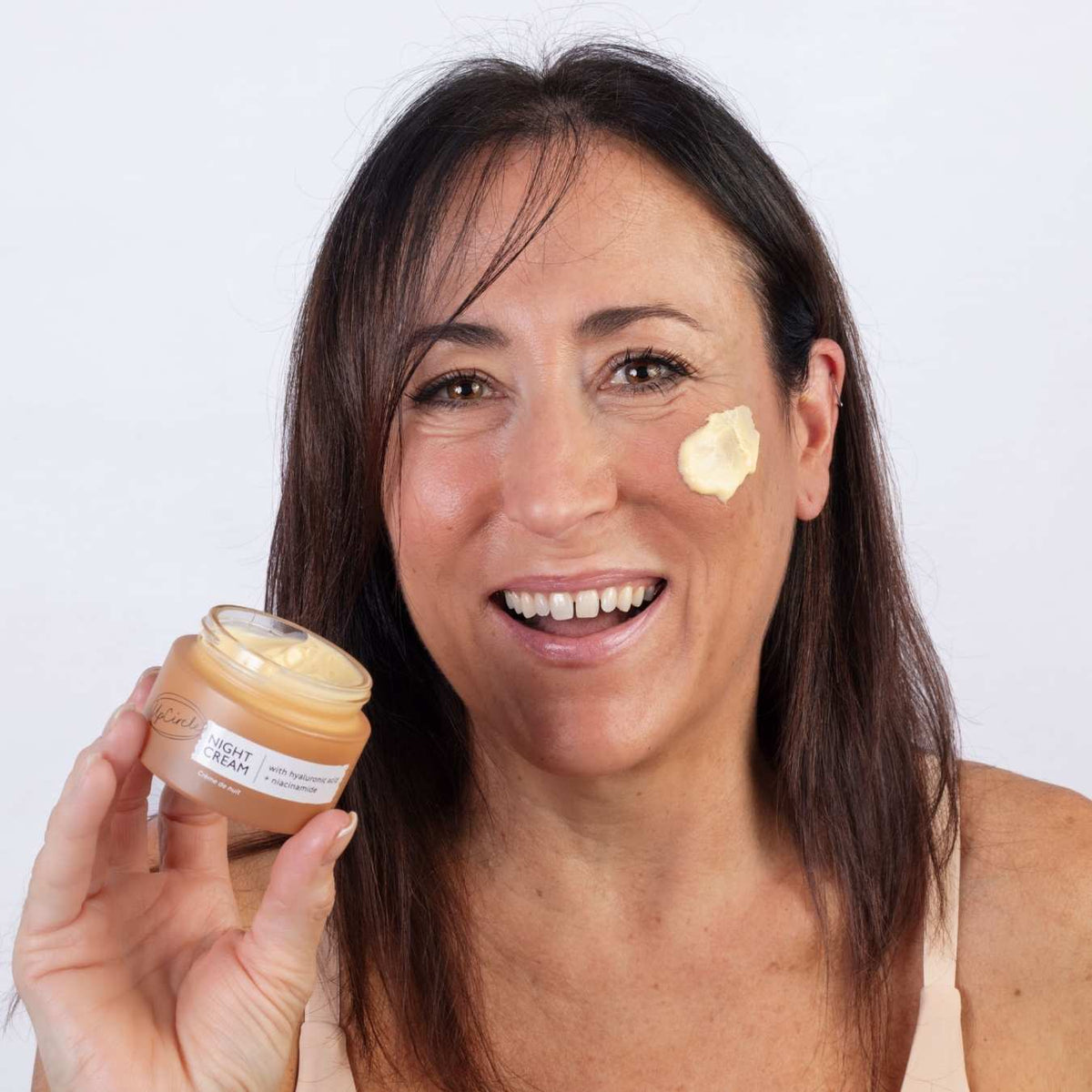 UpCircle Night Cream with Hyaluronic Acid + Niacinamide in beige jar on model's cheek on Tampa Home & Garden Store