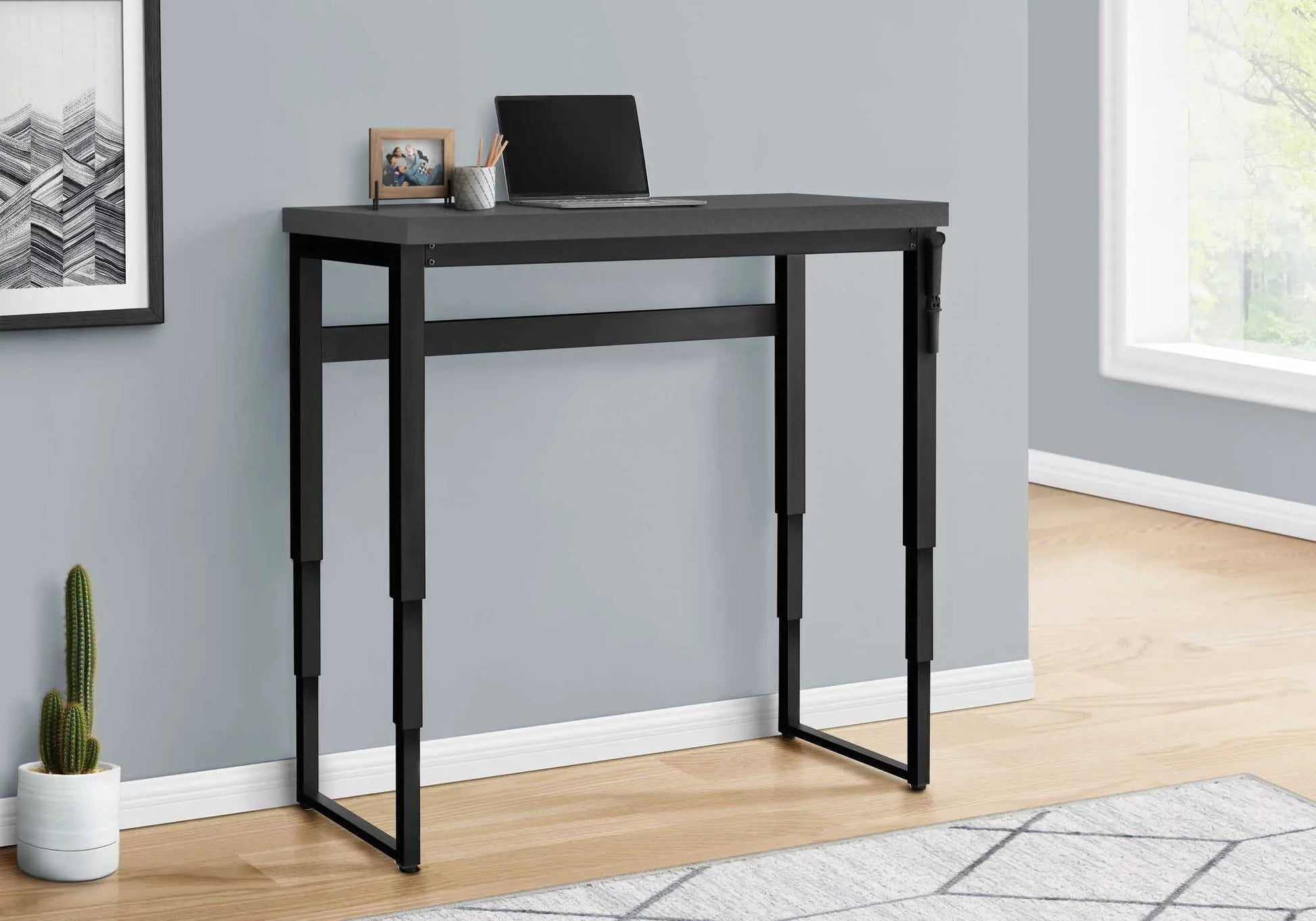 Standing adjustable computer desk with gray top and black frame; laptop on surface on Tampa Home & Garden Store