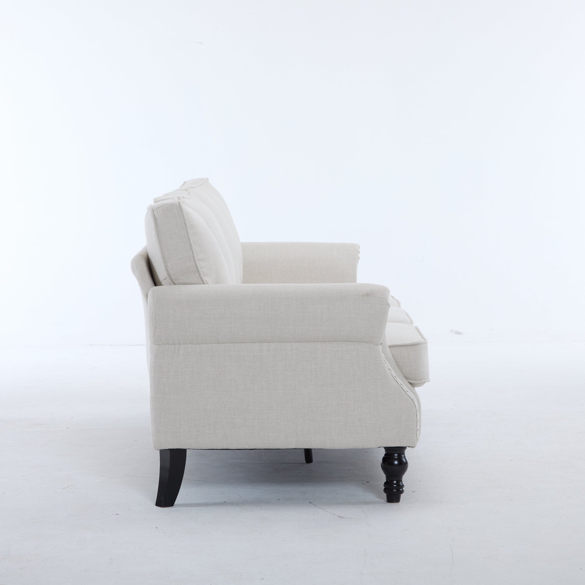 Beige rolled-arm fabric chair with nailhead trim and dark wooden legs on Tampa Home & Garden Store