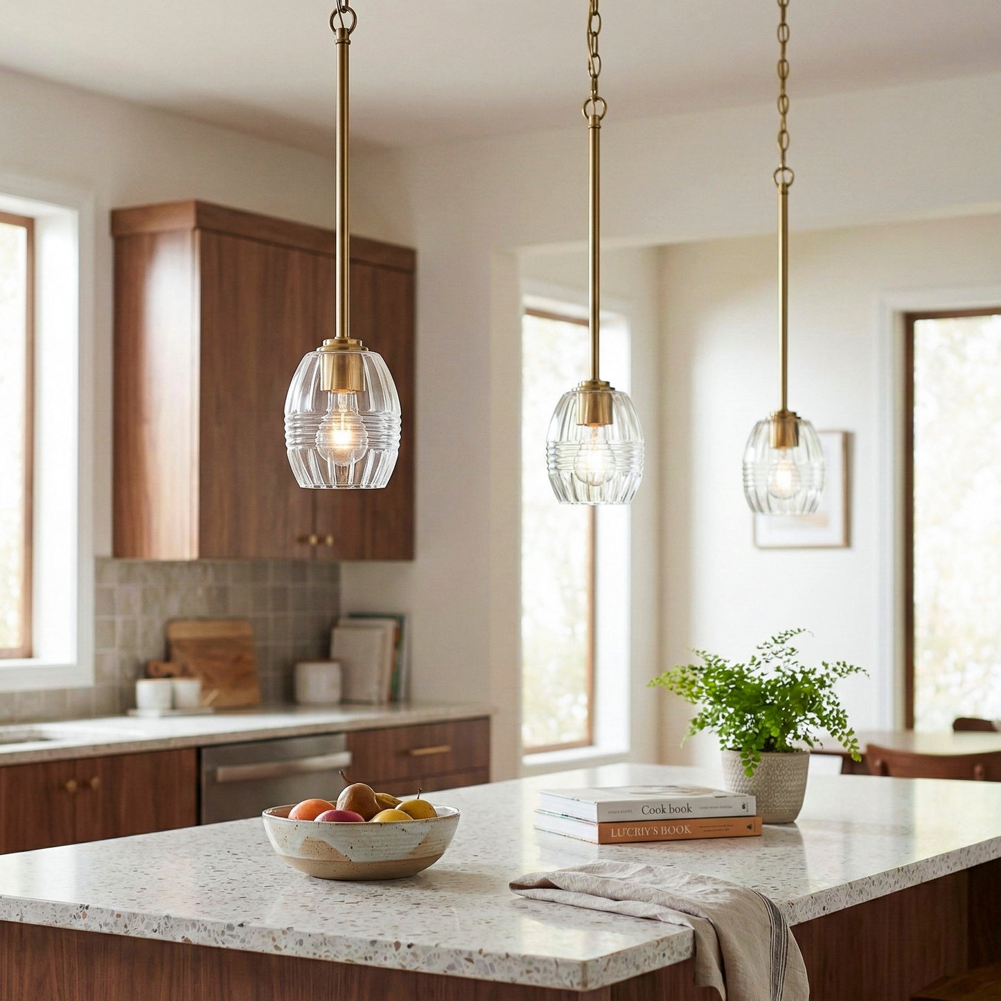 Three Vista pendant lights by HouseOfZazla, clear glass shades with gold hardware over island on Tampa Home & Garden Store