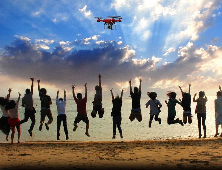 X52 RC drone with Altitude Hold, red quadcopter with 1080P/5MP HD camera over a beach crowd on Tampa Home & Garden Store