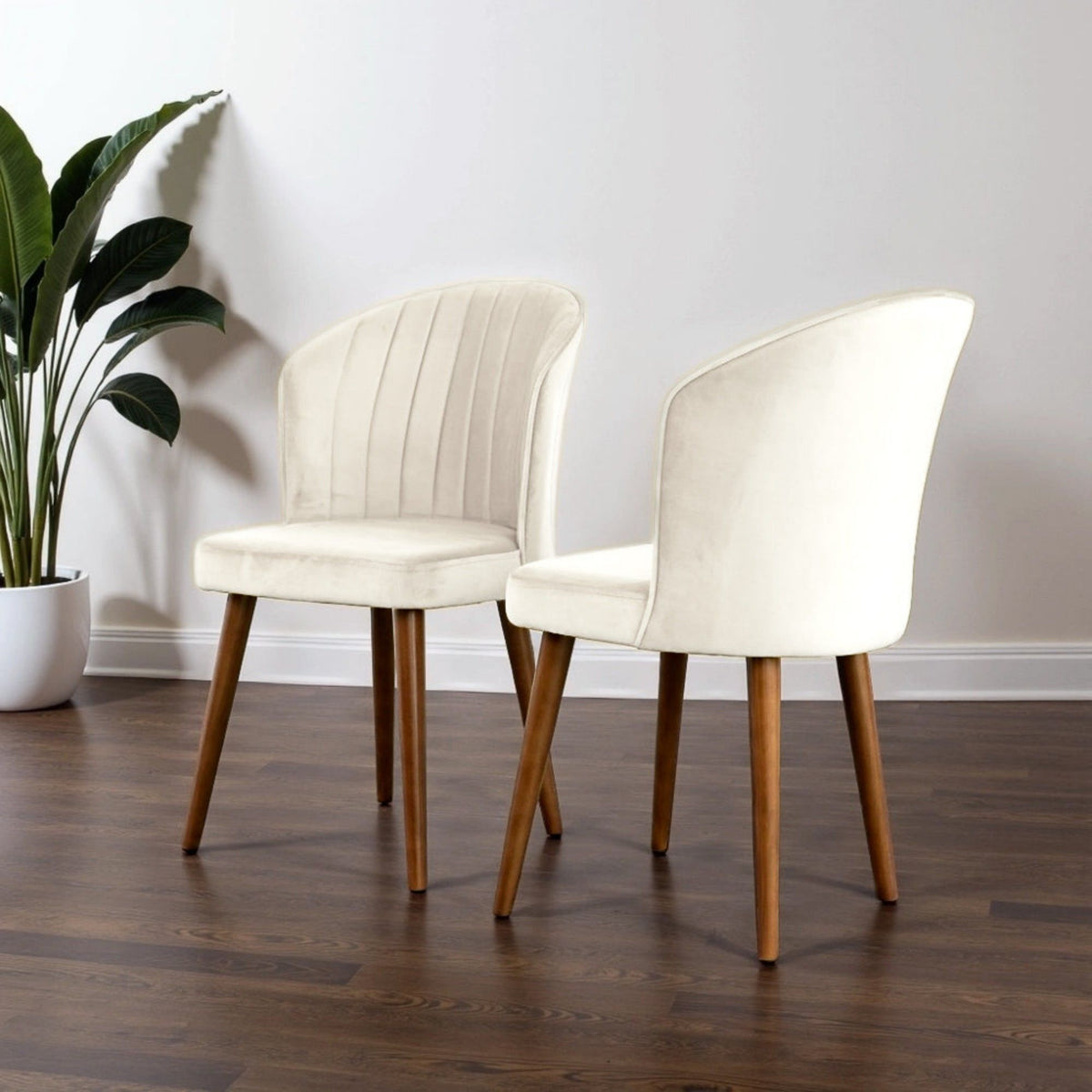 Parsons dining chairs set in beige upholstery with wood legs, two chairs beside a plant on Tampa Home & Garden Store