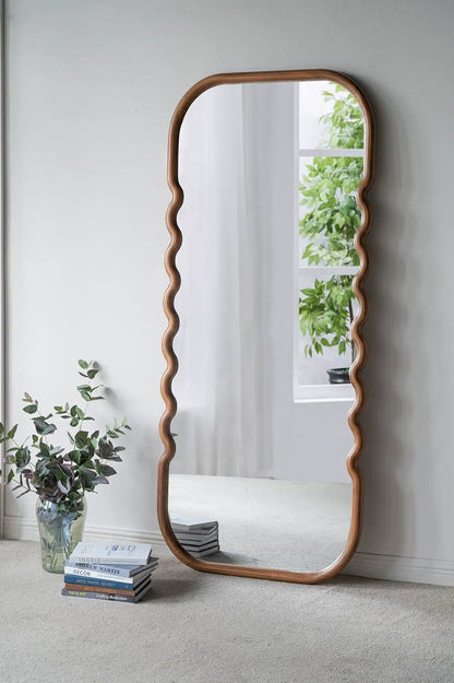 Oversized wooden floor mirror with a brown unique curved frame and wavy side edges on Tampa Home & Garden Store