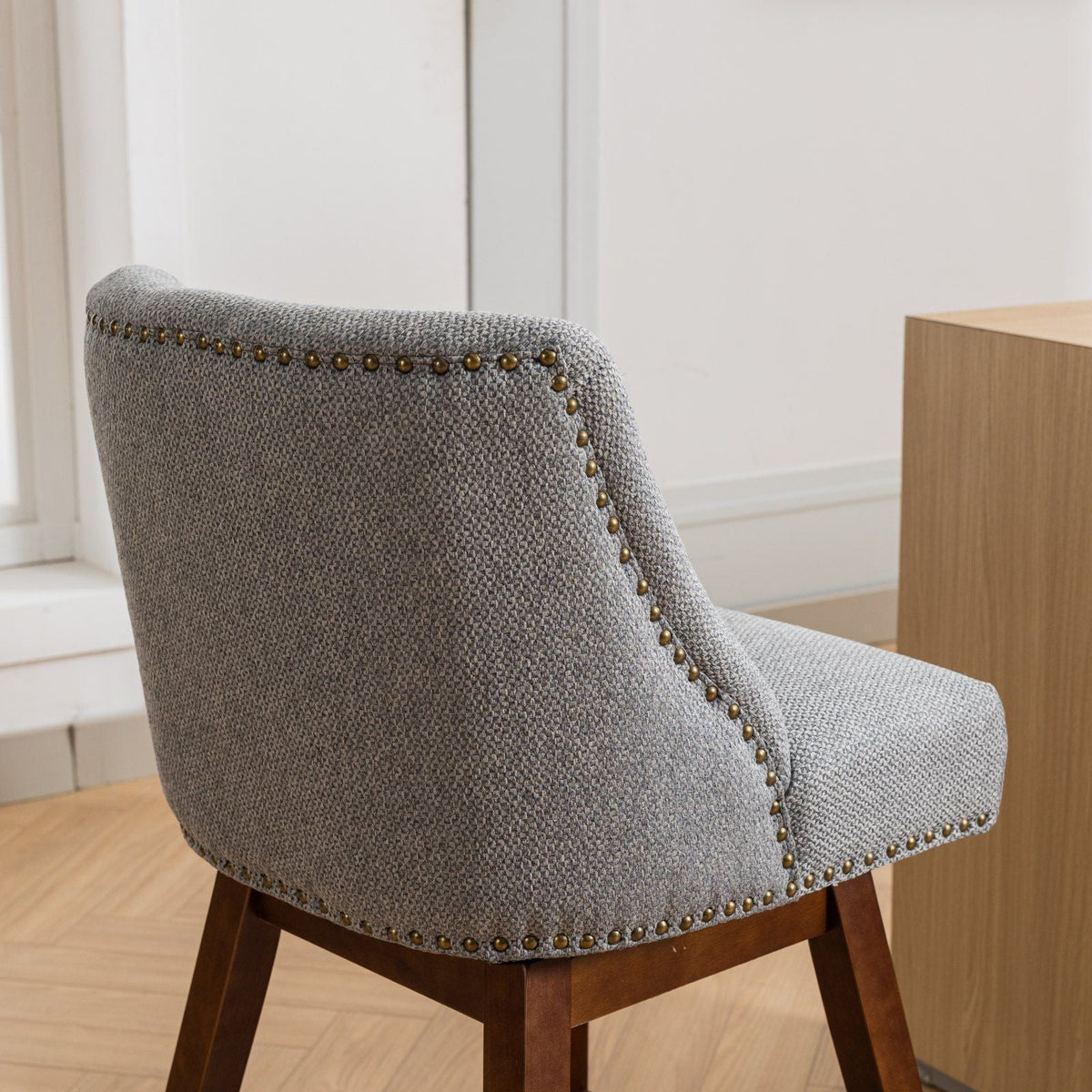 Gray fabric upholstered chair with brass nailhead trim and dark wood legs on Tampa Home & Garden Store
