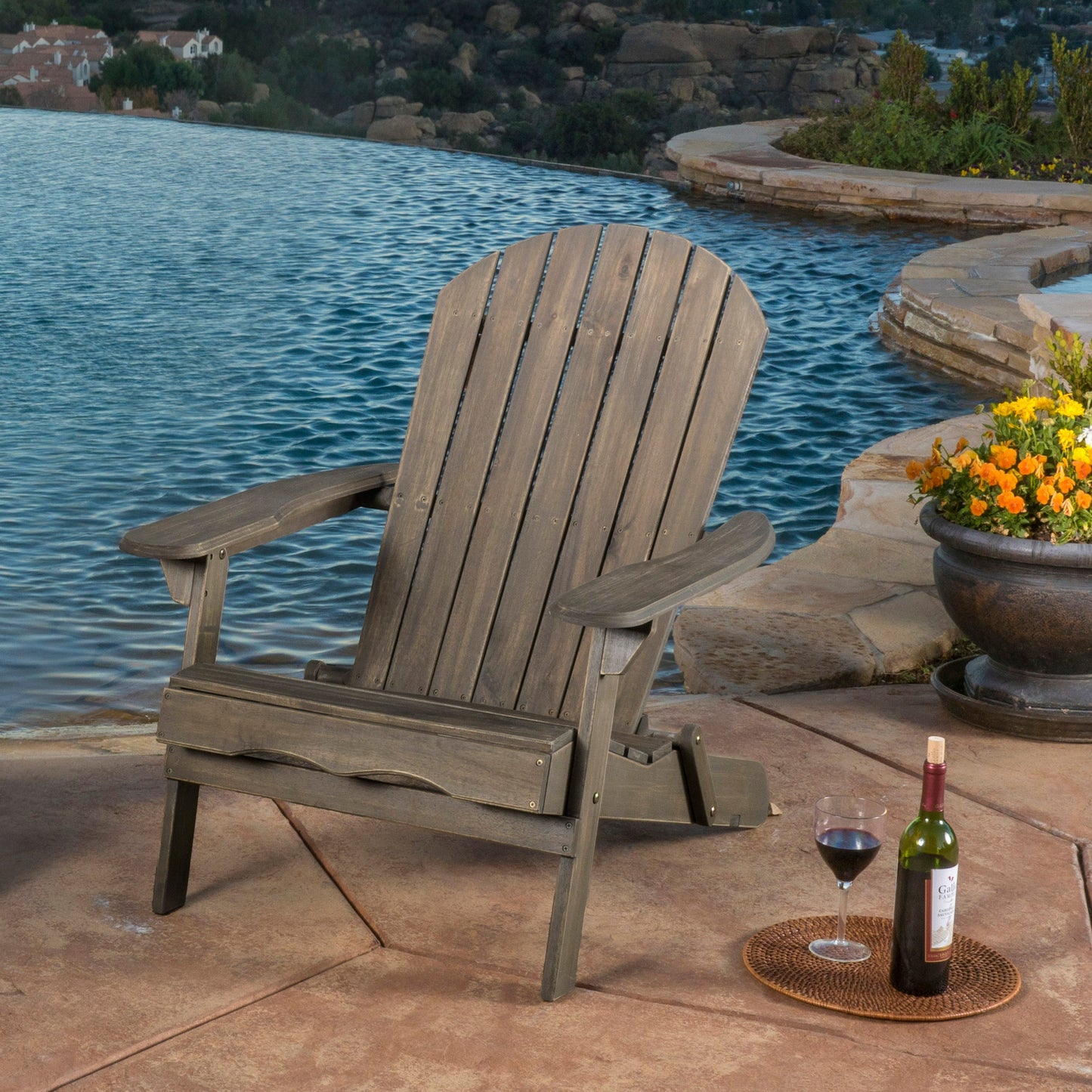 Malibu Adirondack Chair by HouseOfZazla weathered brown wood beside a pool on a stone patio flowers on Tampa Home & Garden Store