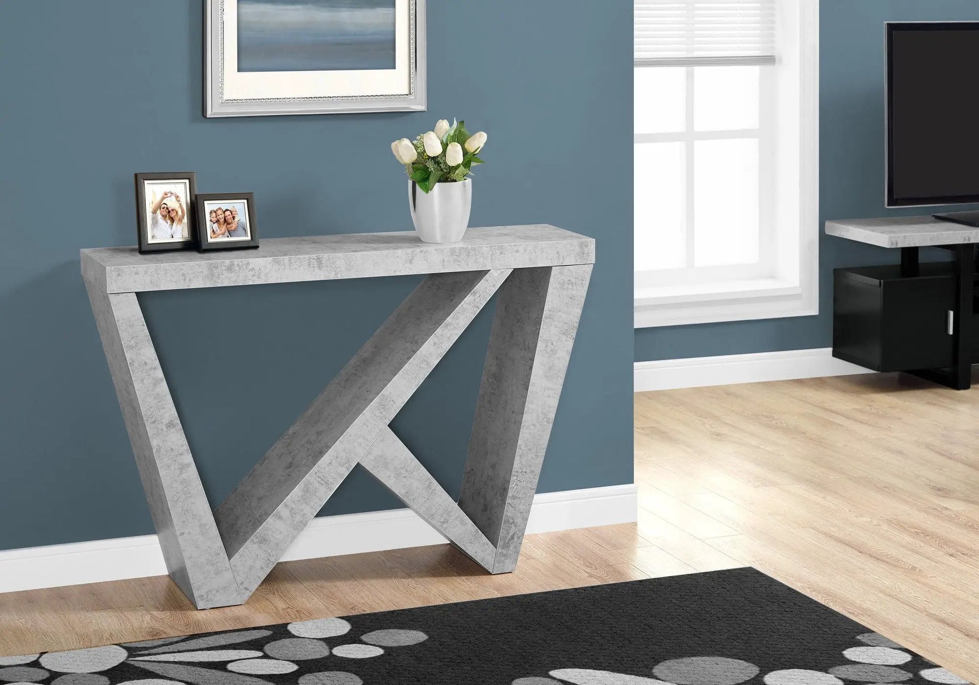 Accent console table with concrete gray finish and X-frame legs, two framed photos on Tampa Home & Garden Store