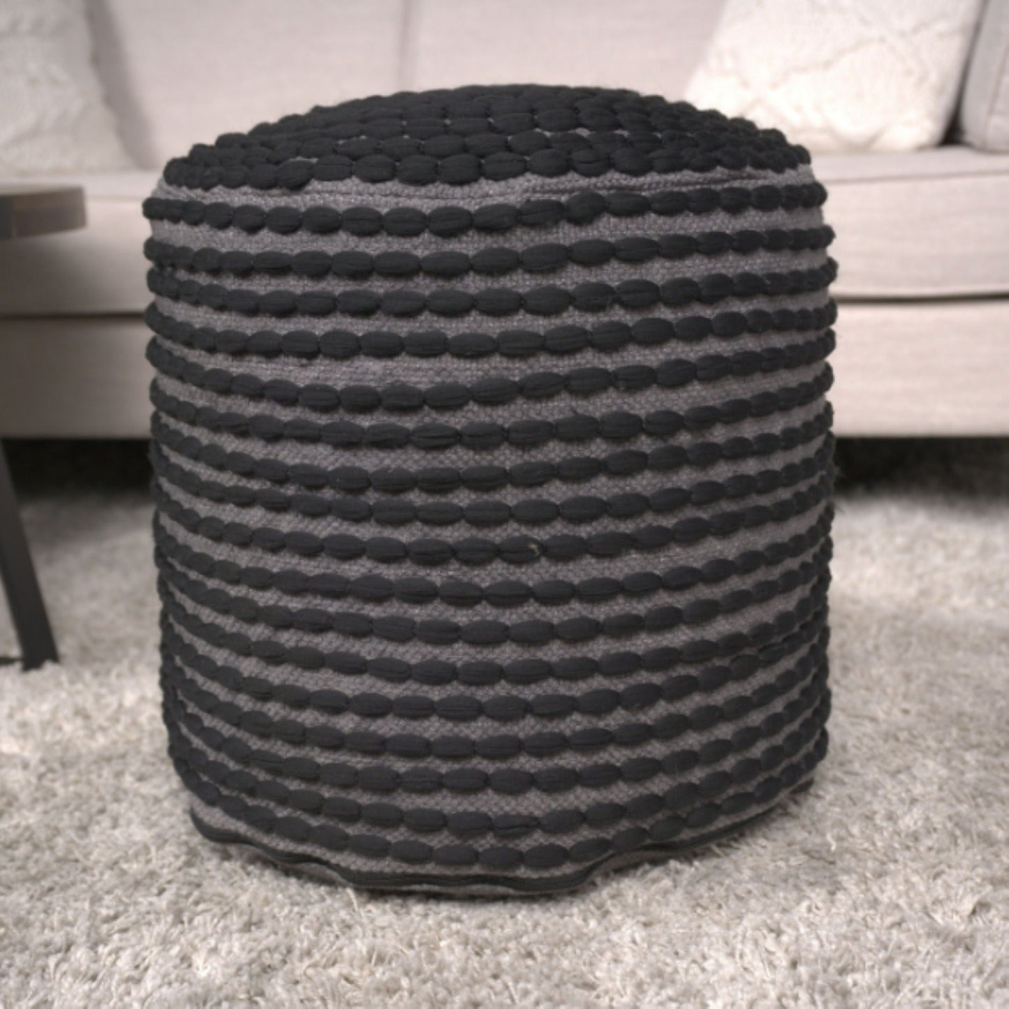 River Handcrafted Cylindrical Pouf in water resistant gray fabric with black pom bands on Tampa Home & Garden Store