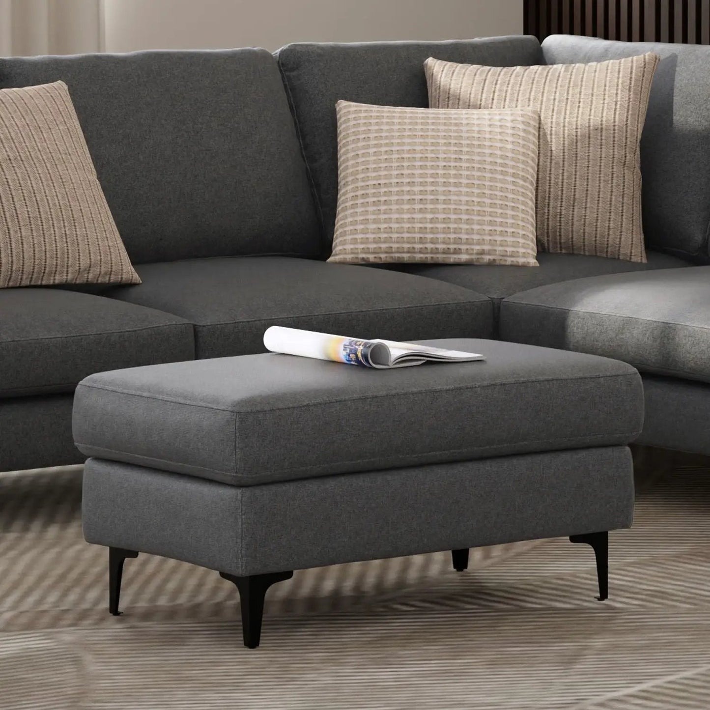 Ava mid-century upholstered ottoman in gray fabric with black tapered legs, magazine on top on Tampa Home & Garden Store