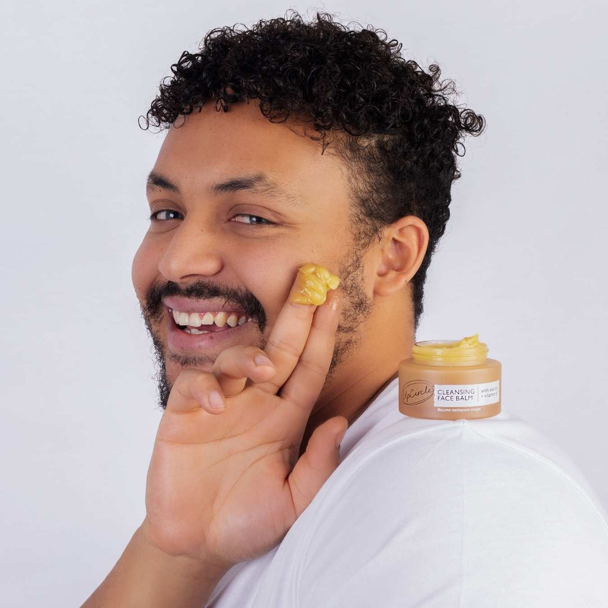 Double Cleansing Duo UpCircle cleansing balm in open jar with yellow balm, man applies on cheek on Tampa Home & Garden Store
