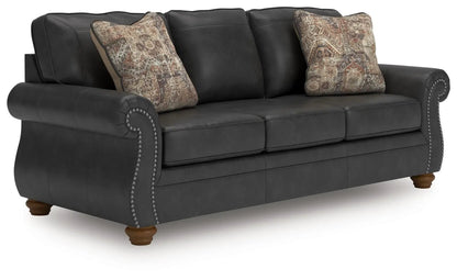 Chasemore Sofa dark gray faux leather stationary sofa with nailhead trim rolled arms on Tampa Home & Garden Store