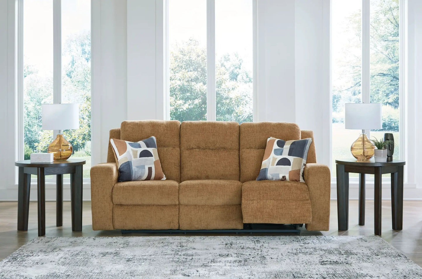 Kanlow reclining sofa in tan fabric with geometric pillows, flanked by two dark wood end tables on Tampa Home & Garden Store