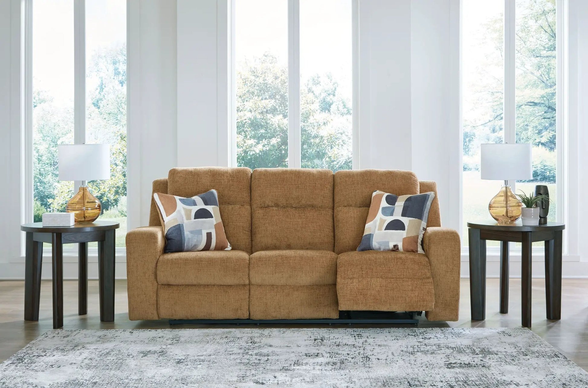 Kanlow reclining sofa in tan fabric with geometric pillows, flanked by two dark wood end tables on Tampa Home & Garden Store
