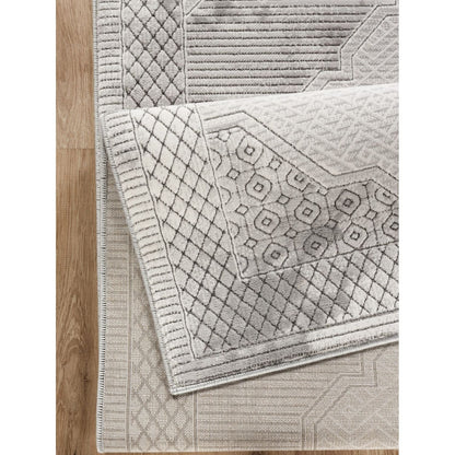 Area rug gray medallion with geometric 3D detail layered over a geometric rug on wood floor on Tampa Home & Garden Store