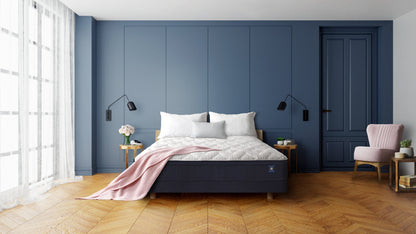 Restonic comfortcare hybrid mattress with firm feel on a blue-paneled bedroom setup with white bedding on Tampa Home & Garden Store