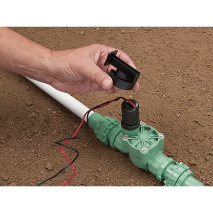 Battery-Powered Sprinkler Controller underground install; hand attaches black collar to valve on Tampa Home & Garden Store