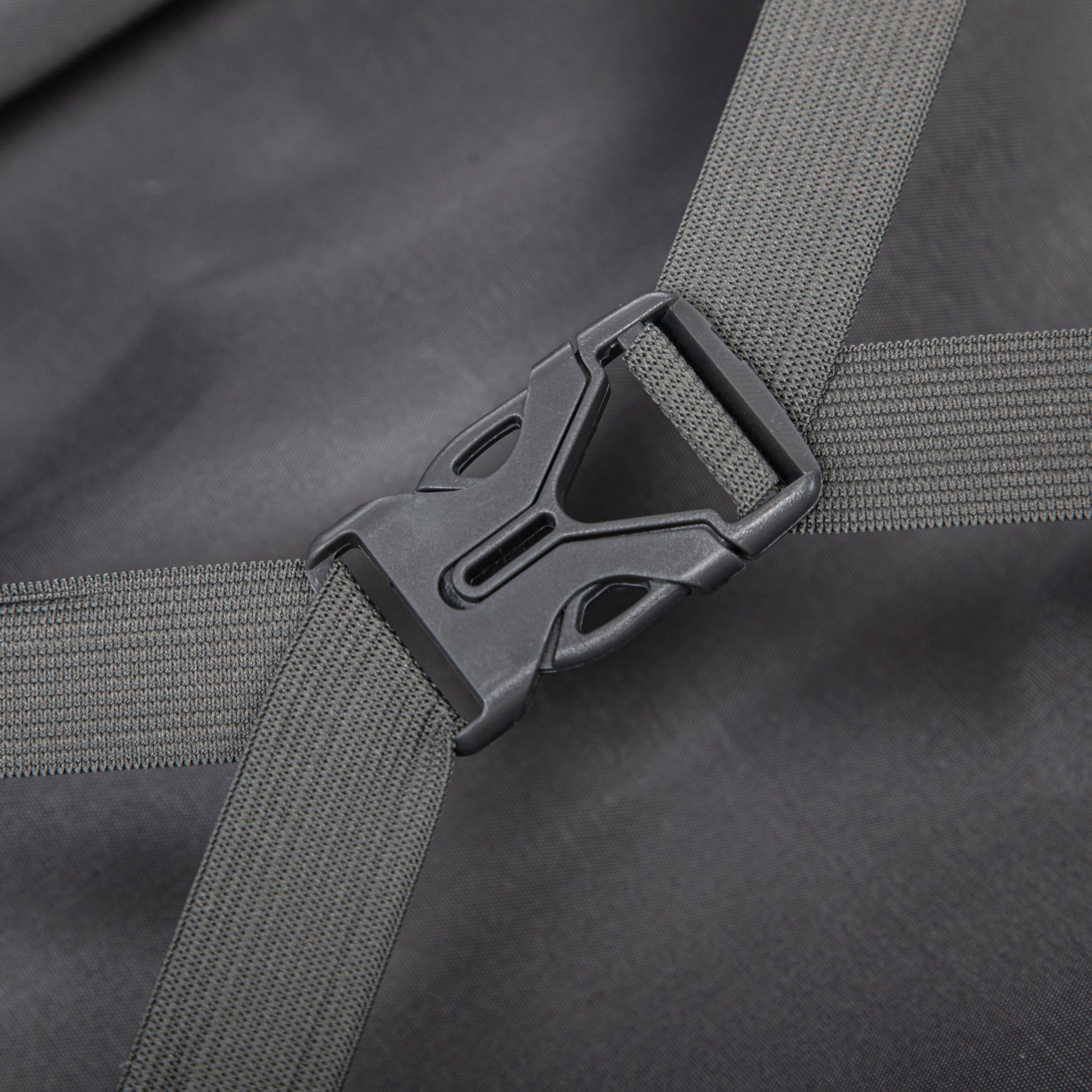 Luggage strap close-up with gray woven webbing and black plastic buckle on dark fabric on Tampa Home & Garden Store