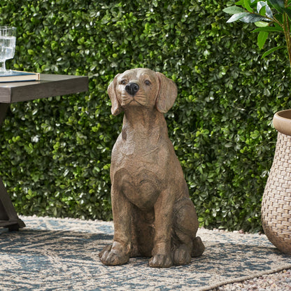 MGO Dog Decor outdoor dog statue in brown weathered finish beside a glass and books on a patio on Tampa Home & Garden Store