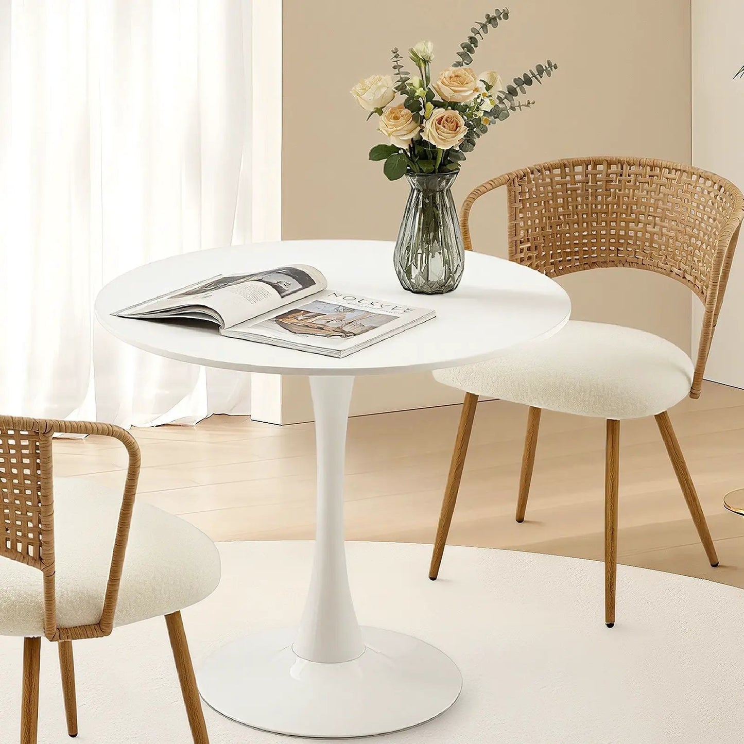 Round dining table with tulip base in white, two woven chairs on Tampa Home & Garden Store