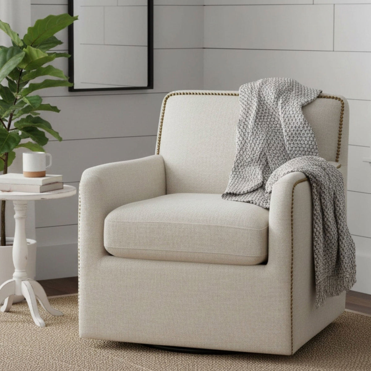 Beige swivel accent chair with antique brass nailhead trim and gray knit throw on Tampa Home & Garden Store
