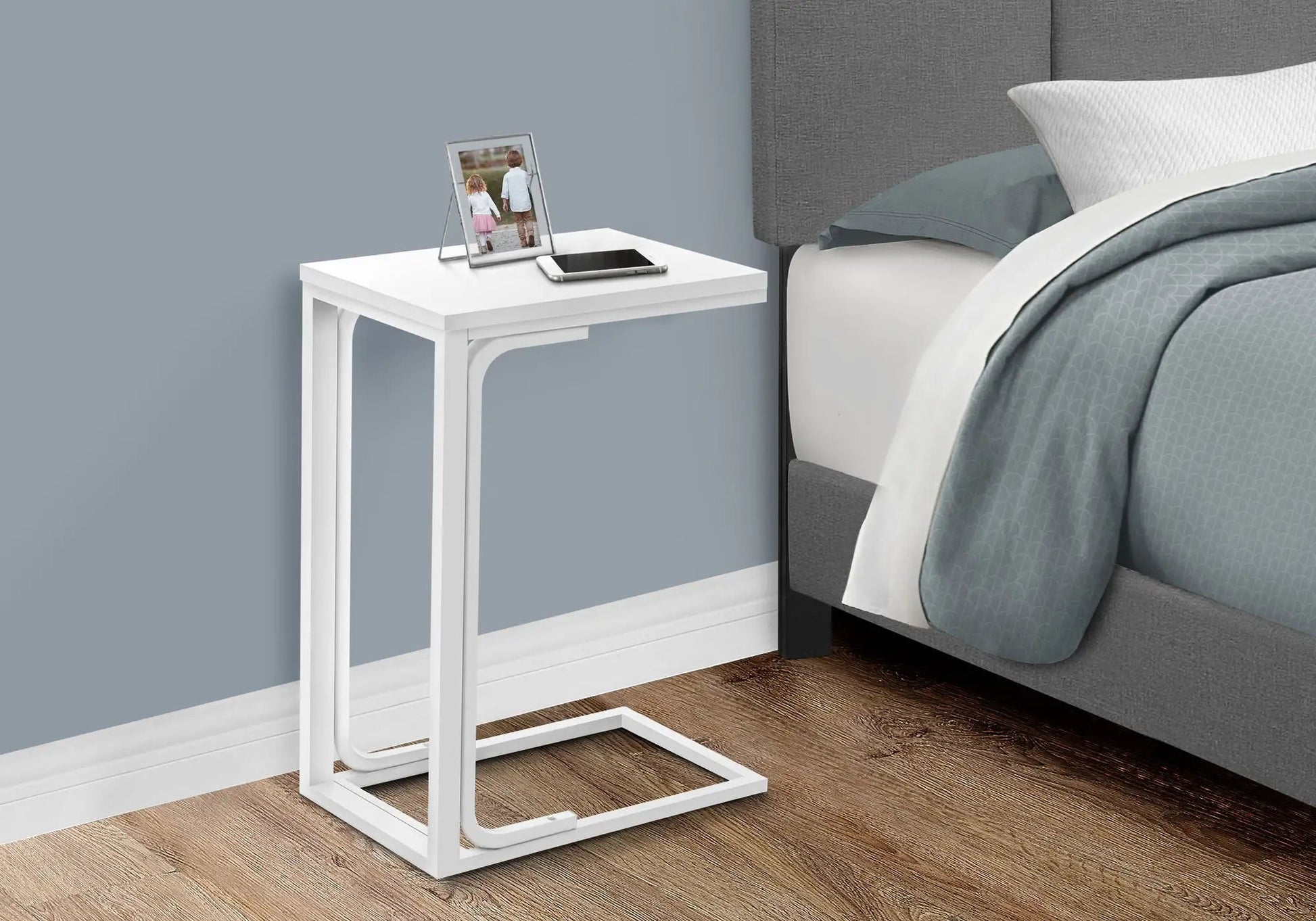C-shaped accent table in white metal with two items on top: photo frame and smartphone on Tampa Home & Garden Store