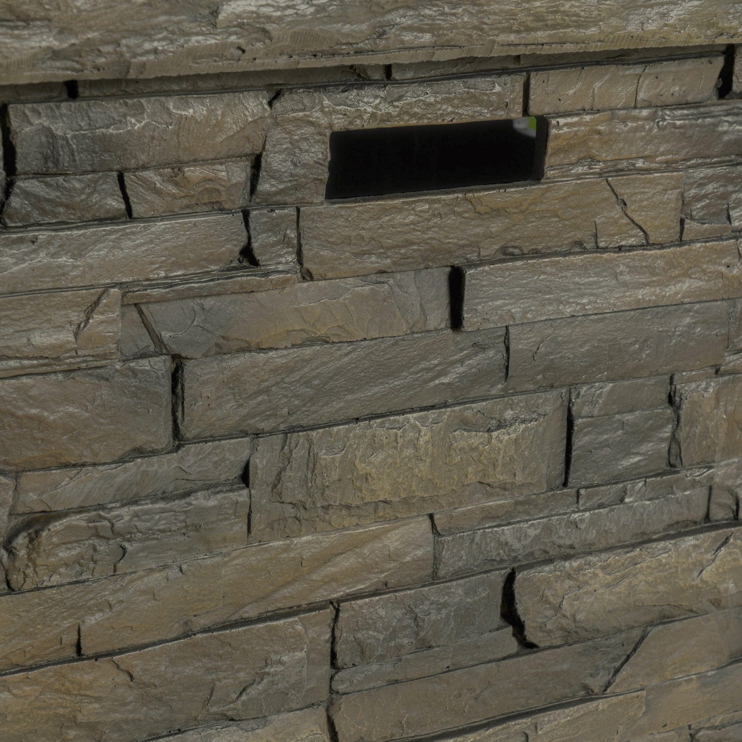 33in square MGO fire pit inset into a textured gray stacked-stone wall on Tampa Home & Garden Store