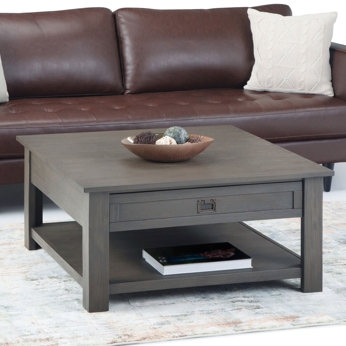 Monroe solid acacia side table in gray-brown with drawer and shelf beside brown leather sofa on Tampa Home & Garden Store