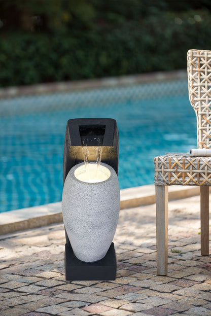 Water fountain with vase design by HouseOfZazla, gray speckled vase on black pedestal by poolside on Tampa Home & Garden Store