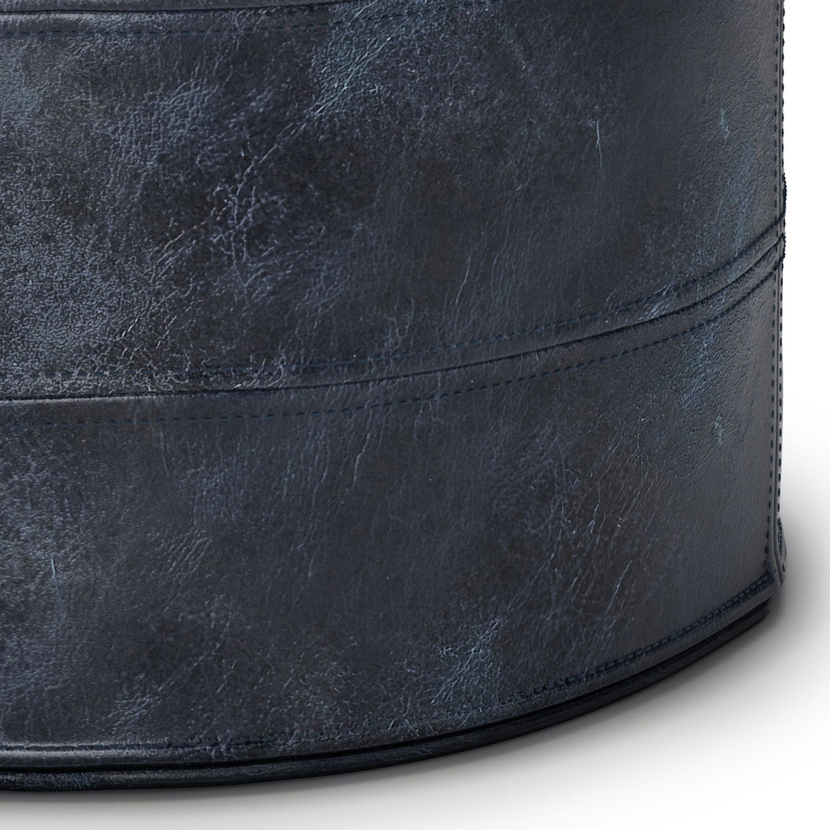 Handcrafted round pouf in distressed navy leather with visible stitching on Tampa Home & Garden Store
