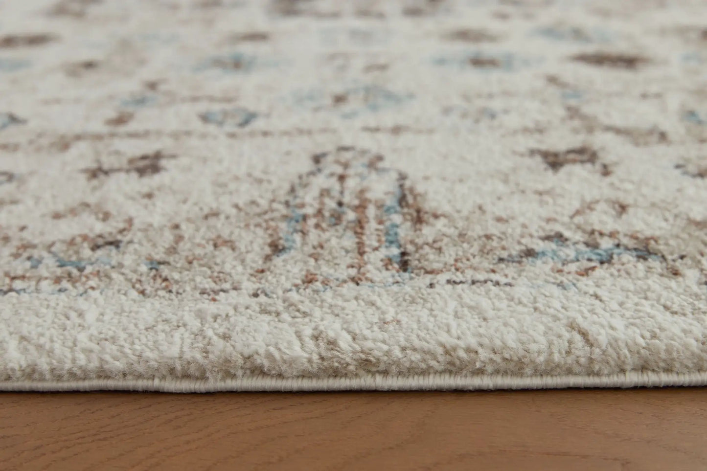Jossler rug by Unique Piece Furniture, beige plush area rug with blue/brown accents edge binding on Tampa Home & Garden Store