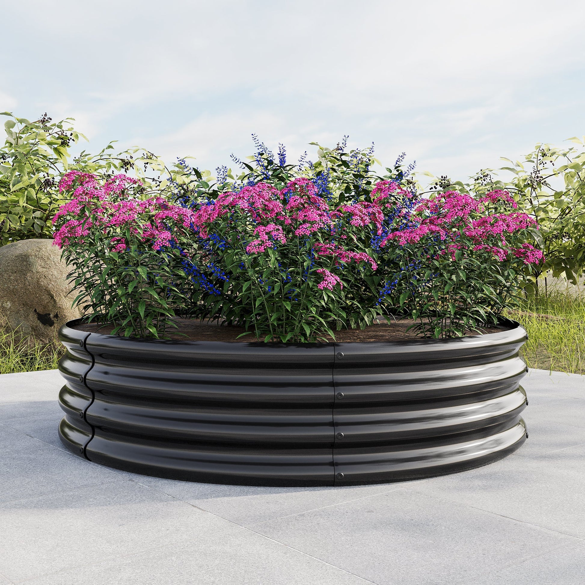 Round raised garden bed planter black metal container with pink and blue flowering plants on Tampa Home & Garden Store