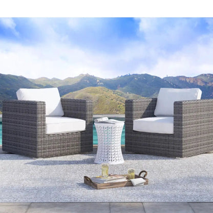 Two patio arm chairs with white cushions in brown wicker by Unique Piece Furniture on Tampa Home & Garden Store