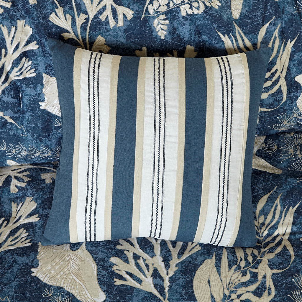 Striped blue, white, and beige decorative pillow on navy coral-print bedding on Tampa Home & Garden Store