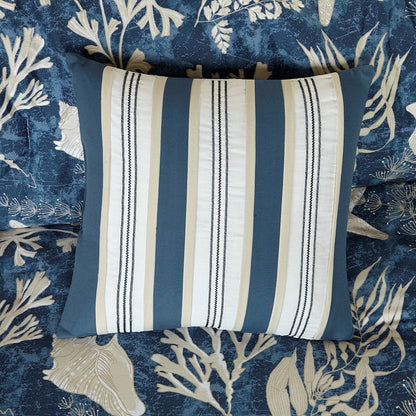 Striped blue, white, and beige decorative pillow on navy coral-print bedding on Tampa Home & Garden Store
