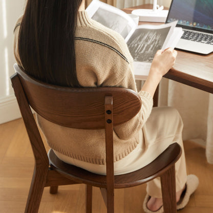 Simple dining chair solid wood walnut finish with curved back in a living room setting on Tampa Home & Garden Store