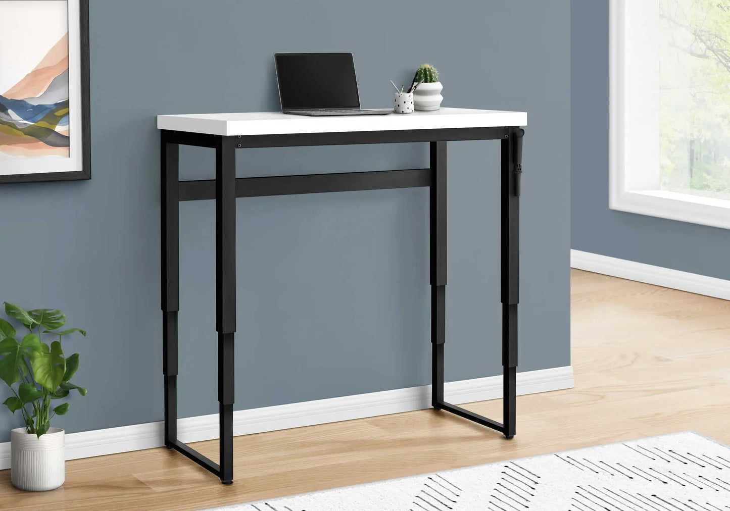 Standing adjustable computer desk with white top and black metal frame, laptop ready on Tampa Home & Garden Store