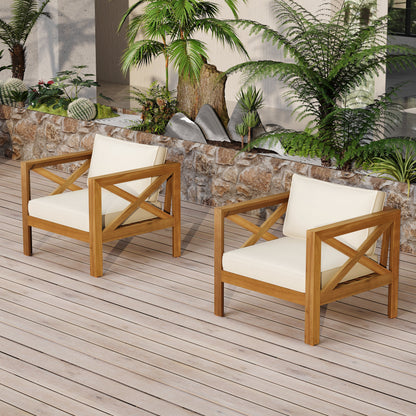 Outdoor club chairs in natural acacia wood with white cushions on a wooden deck on Tampa Home & Garden Store