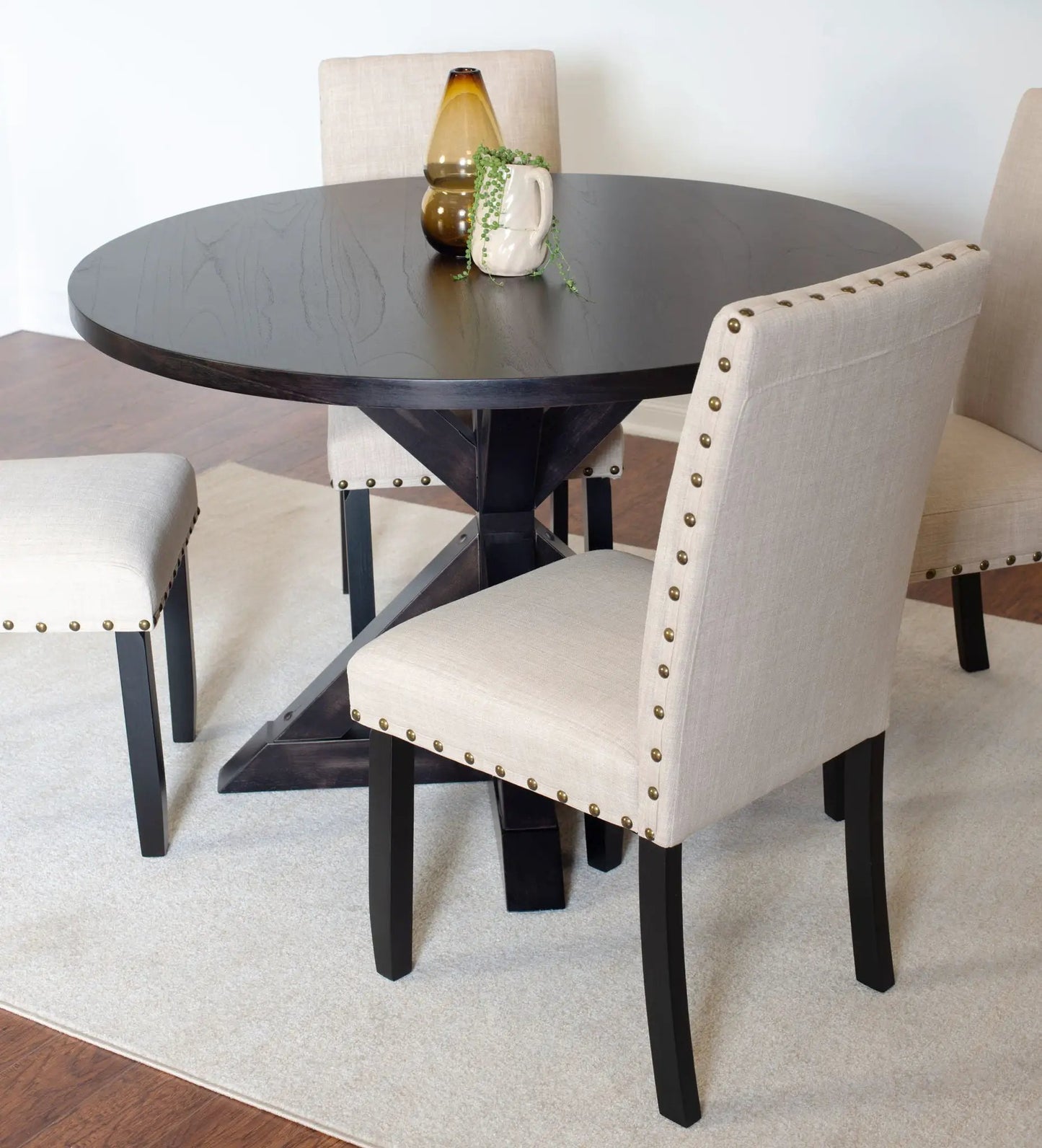 Mytzi 5-piece dining set: black cross-buck round table with beige upholstered chairs on Tampa Home & Garden Store