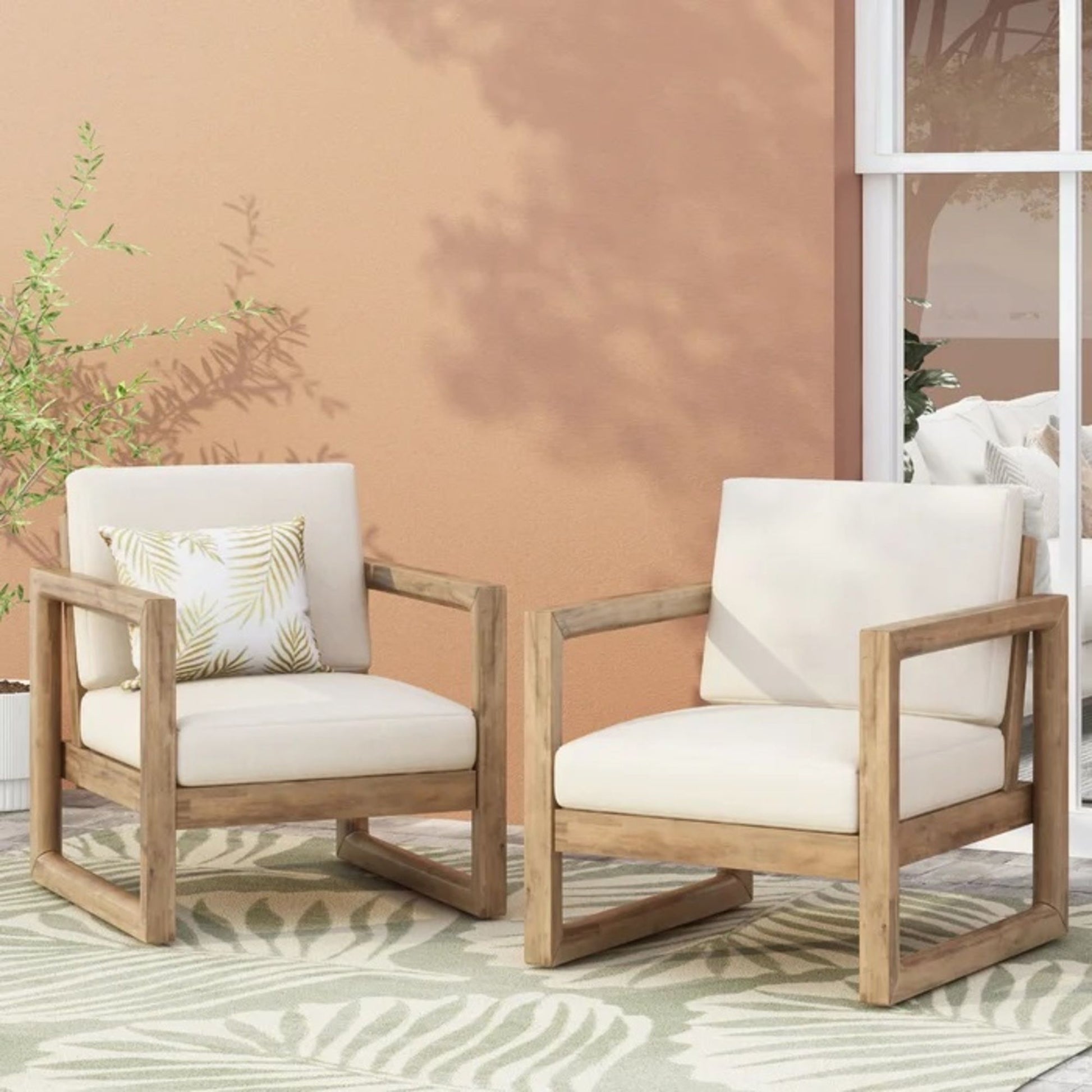 Pair of outdoor acacia wood patio club chairs by HouseOfZazla with cream cushions on Tampa Home & Garden Store
