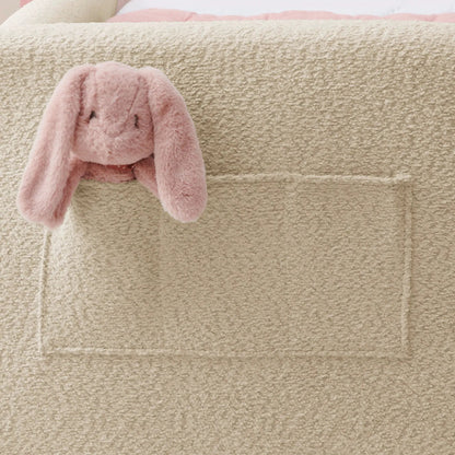 Beige upholstered platform bed frame with pink plush bunny on edge on Tampa Home & Garden Store