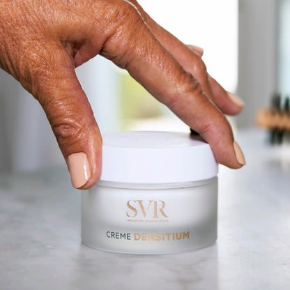 SVR Creme Densitium face cream jar held by hand; frosted white container with gold logo on Tampa Home & Garden Store