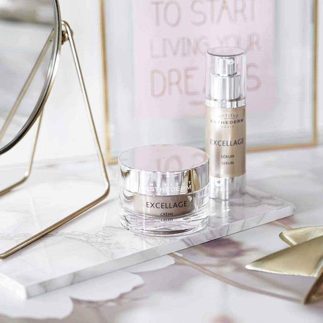 Institut Esthederm Excellage serum bottle beside Excellage cream jar on marble tray on Tampa Home & Garden Store