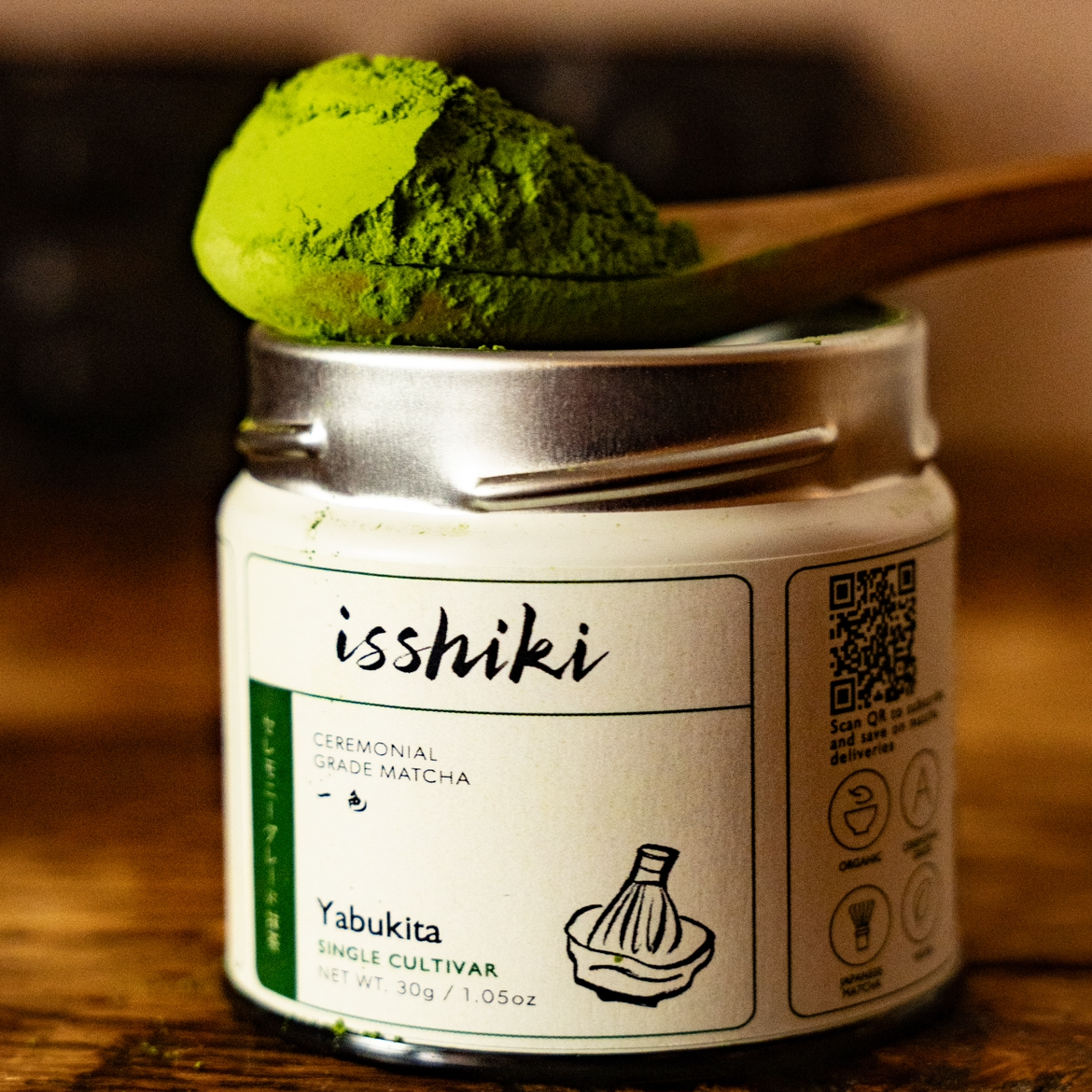 Yabukita ceremonial grade matcha by isshiki in white jar with green powder on a spoon on Tampa Home & Garden Store