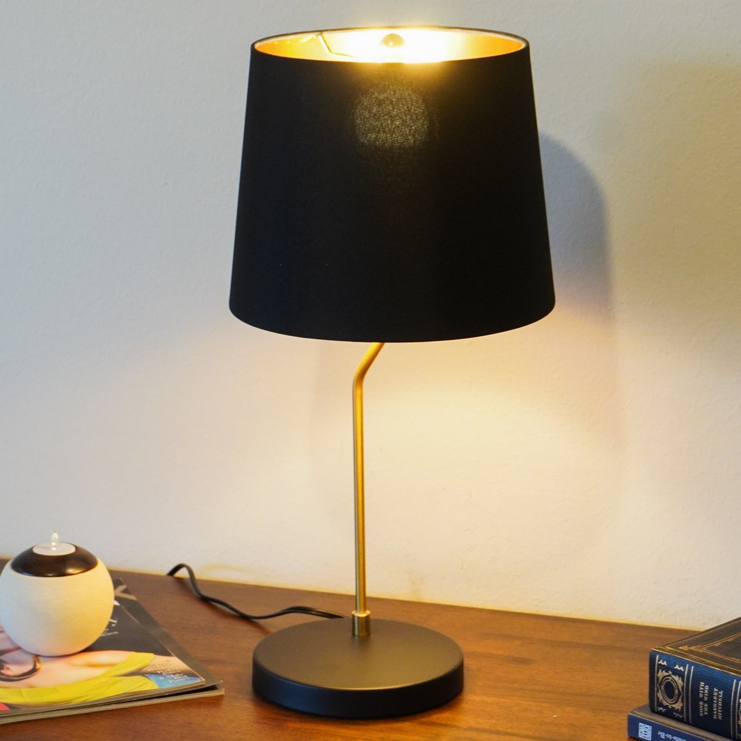 Desk lamp with black shade and gold metal stem on a wooden desk on Tampa Home & Garden Store