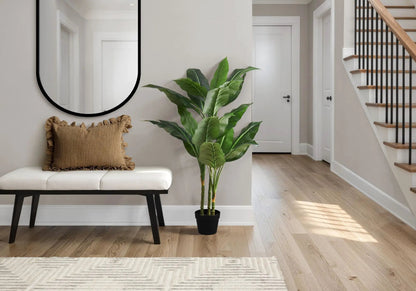 Artificial plant with large green tropical leaves in a black pot by a hallway on Tampa Home & Garden Store