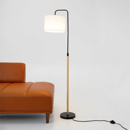 Lior arc floor lamp with black metal curved arm and white cylinder shade beside orange sofa on Tampa Home & Garden Store